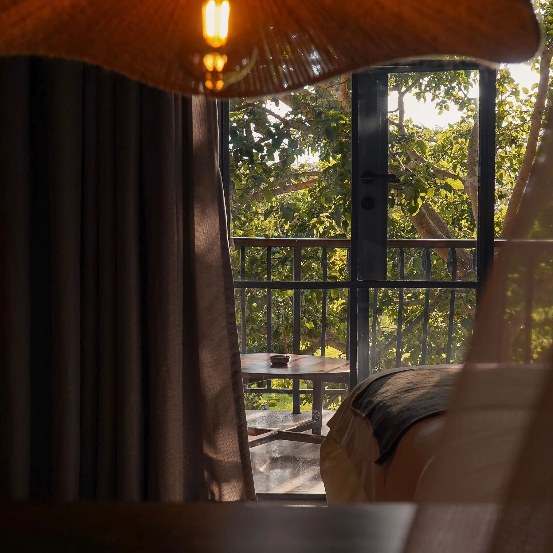 Room with a balcony opening onto the trees