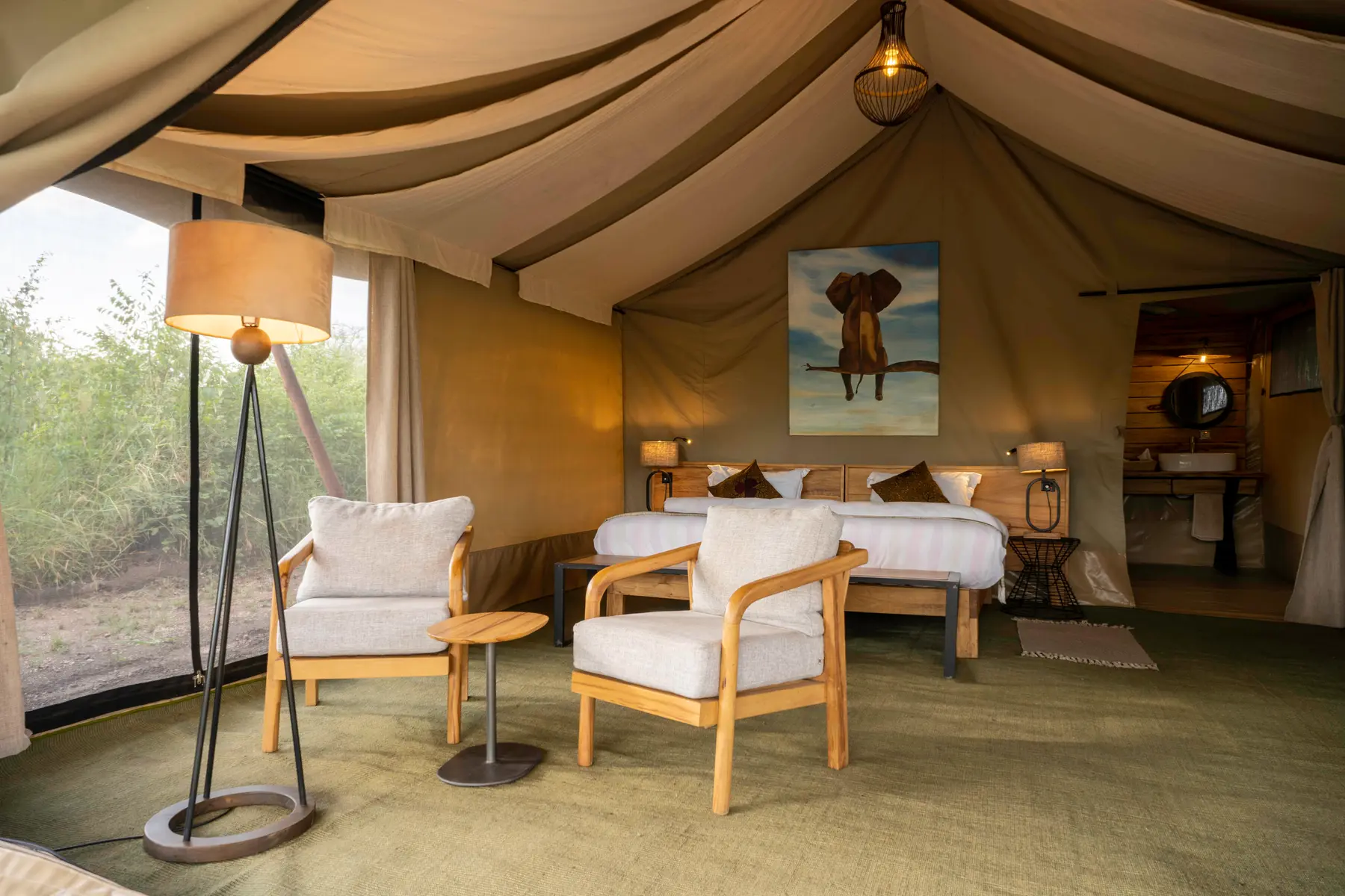 Tent interior with double bed and armchairs