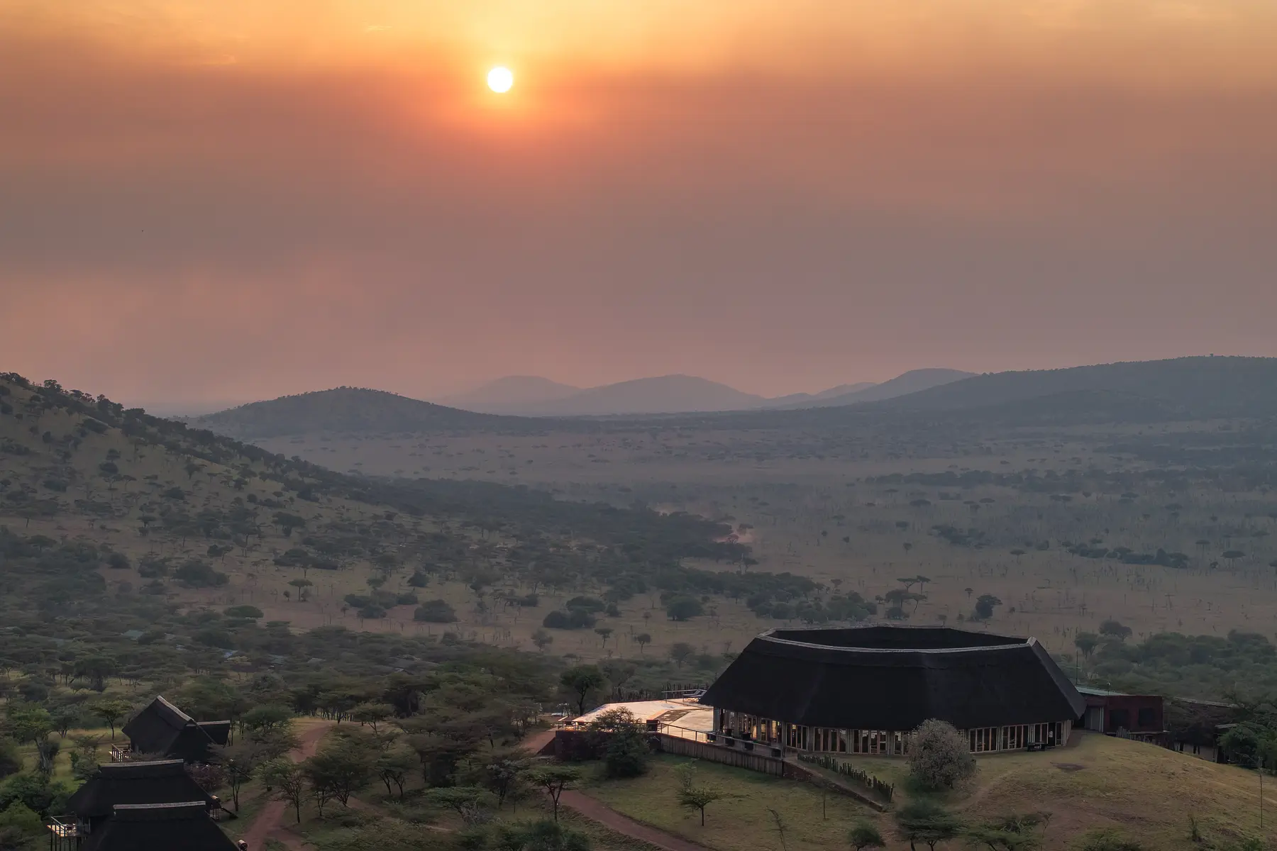Aerial view of the lodge on its hilltop at sunset