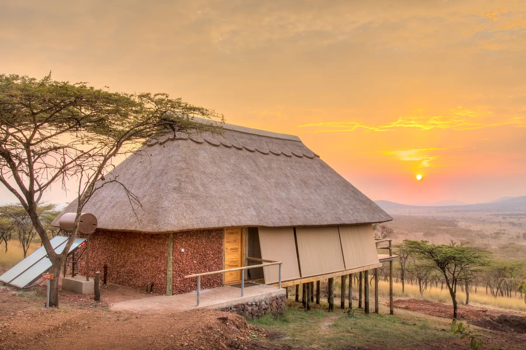 Thatched tent on stilts at sunset